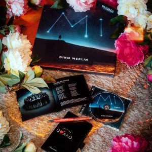 U svakoj noti 𝐚𝐥𝐛𝐮𝐦𝐚 𝐌𝐢 krije se emocija koja pronađe put pravo do srca &ndash; pronađite onu koja govori ba&scaron; vama uz stihove 𝐃𝐢𝐧𝐞 𝐌𝐞𝐫𝐥𝐢𝐧𝐚 🎶✨

🧚𝐉𝐚𝐬𝐭𝐮𝐤 "𝐒𝐫𝐞𝐭𝐧𝐨 𝐭𝐢 𝐛𝐢𝐥𝐨 𝐯𝐢𝐥𝐨, 𝐬𝐯𝐞 𝐭𝐢 𝐬𝐞 𝐩𝐨𝐳𝐥𝐚𝐭𝐢𝐥𝐨"
Dekorativni jastuk inspirisan stihom iz pjesama "Briga" i "Godino vrela" Dine Merlina sa albuma "Mi".

📓𝐑𝐨𝐤𝐨𝐯𝐧𝐢𝐤 𝐀𝟔 𝐟𝐨𝐫𝐦𝐚𝐭𝐚 "𝐙𝐚𝐮𝐯𝐢𝐣𝐞𝐤 𝐨𝐯𝐚𝐤𝐨"
Bez obzira da li idete u &scaron;kolu, studirate, radite ili jednostavno imate potrebu da svoje misli, ideje, planove i obaveze zapisujete na jednom mjestu, ovaj rokovnik (notes) s va&scaron;im omiljenim stihom savr&scaron;en je odabir za vas.

🖼️ 𝐒𝐥𝐢𝐤𝐚 𝐧𝐚 𝐩𝐥𝐚𝐭𝐧𝐮 "𝐌𝐢"
Dizajn inspirisan omotom 12. studijskog albuma Dine Merlina pod nazivom "Mi".

📀 𝐀𝐥𝐛𝐮𝐦 "𝐌𝐢" 𝐃𝐢𝐧𝐞 𝐌𝐞𝐫𝐥𝐢𝐧𝐚 𝐧𝐚 𝐂𝐃
Izdanje uz bogatu knjižicu fotografija i tekstova svih 18 pjesama, 11 novih uz 7 već ranije objavljenih singlova. Suvenir je jednog vremena, priča satkana od zvijezda, nota i riječi. Savr&scaron;en poklon i dragocjena kolekcionarska uspomena za one koji znaju &scaron;ta znači voljeti muziku.

#dinomerlin #dinomerlinofficial #svijetmagaze