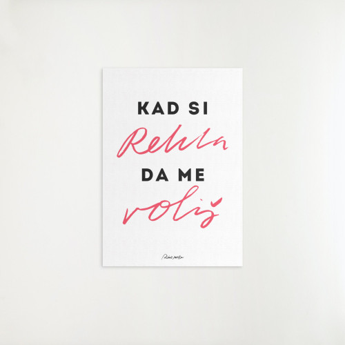 Dekorativni poster "Kad si rekla da me voliš" sa crveno-crnim slovima, i sa originalnim potpisom "Dino Merlin" okačen na bijeli zid.