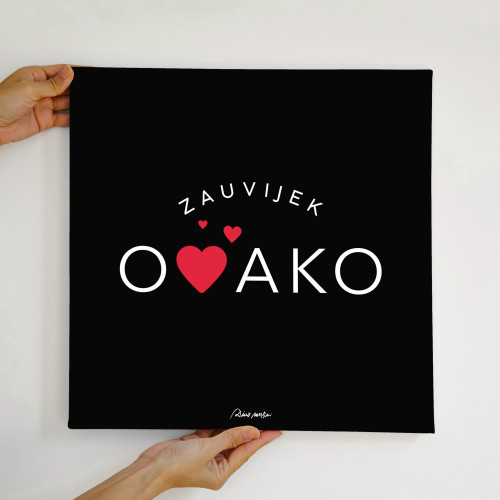 Crni dekorativni poster sa bijelim slovima i crvenim srcima “Zauvijek ovako” iz istoimene pjesme u rukama osobe na bijeloj pozadini.
