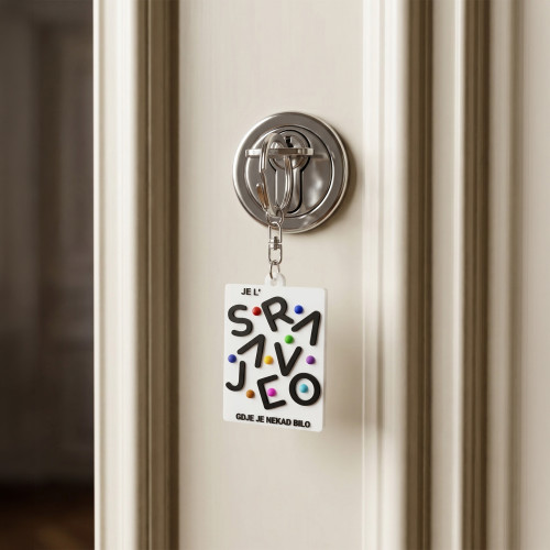 Bijeli privjesak za ključeve "Je l' Sarajevo gdje je nekad bilo" u ključaonici bijelih vrata. 
