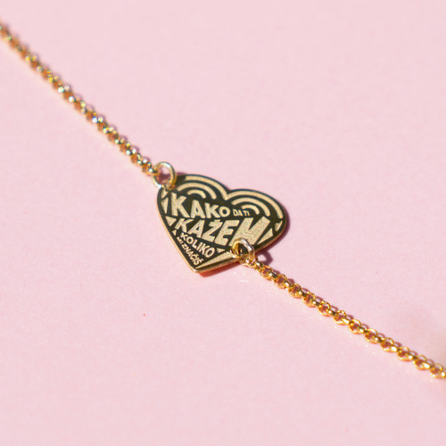 Srebrena narukvica s gold ili rose gold pozlatom s stihom "Kako da ti kažem koliko mi značiš" na rozoj pozadini.